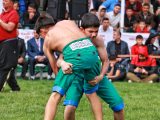 Two young athletes compete in a traditional Turkish oil wrestling match outdoors. — The Evolving Landscape of Sports Narrativ